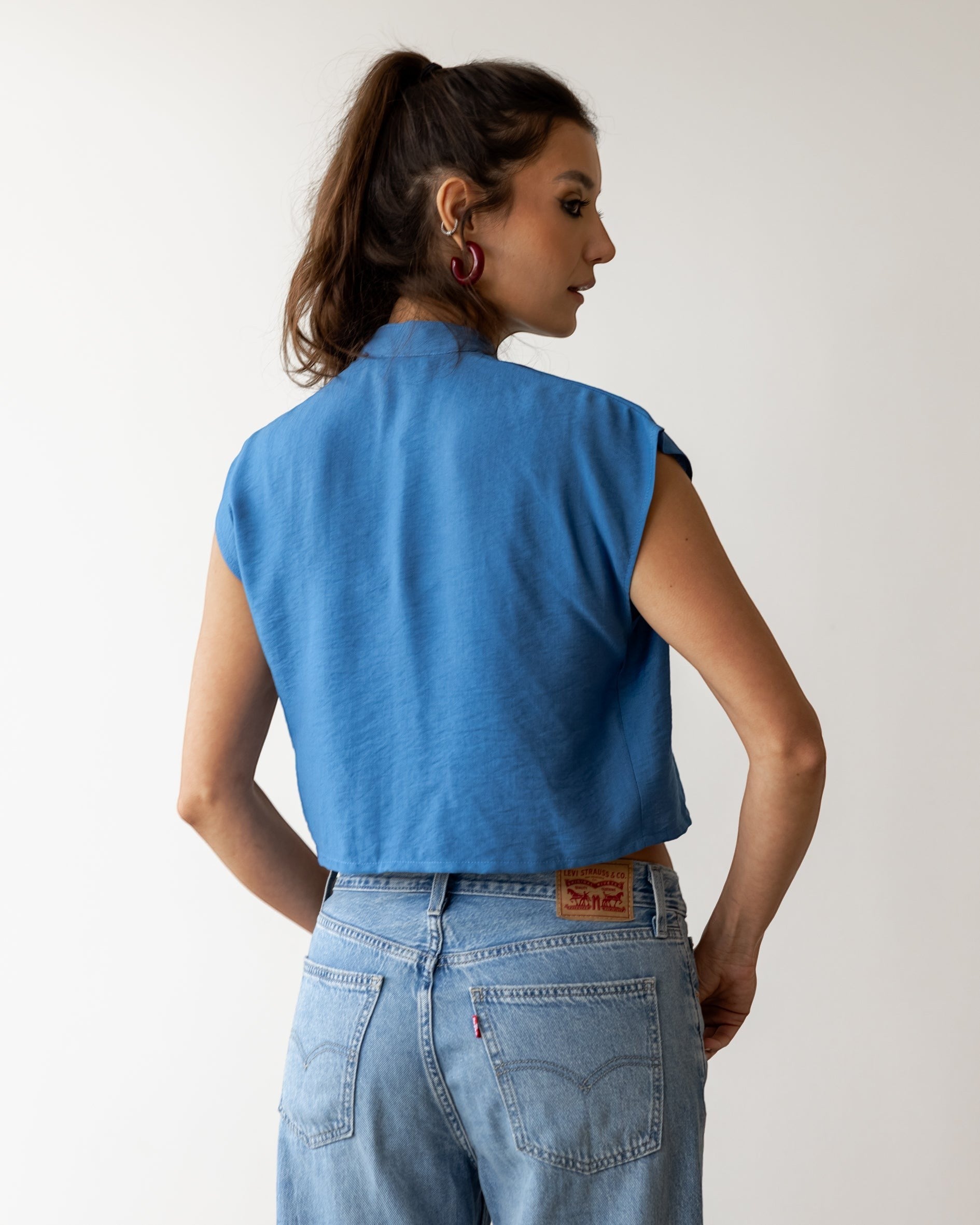 FSociety steel blue lightweight fabric knot top with mock neck, cap sleeves, and cropped open hem.