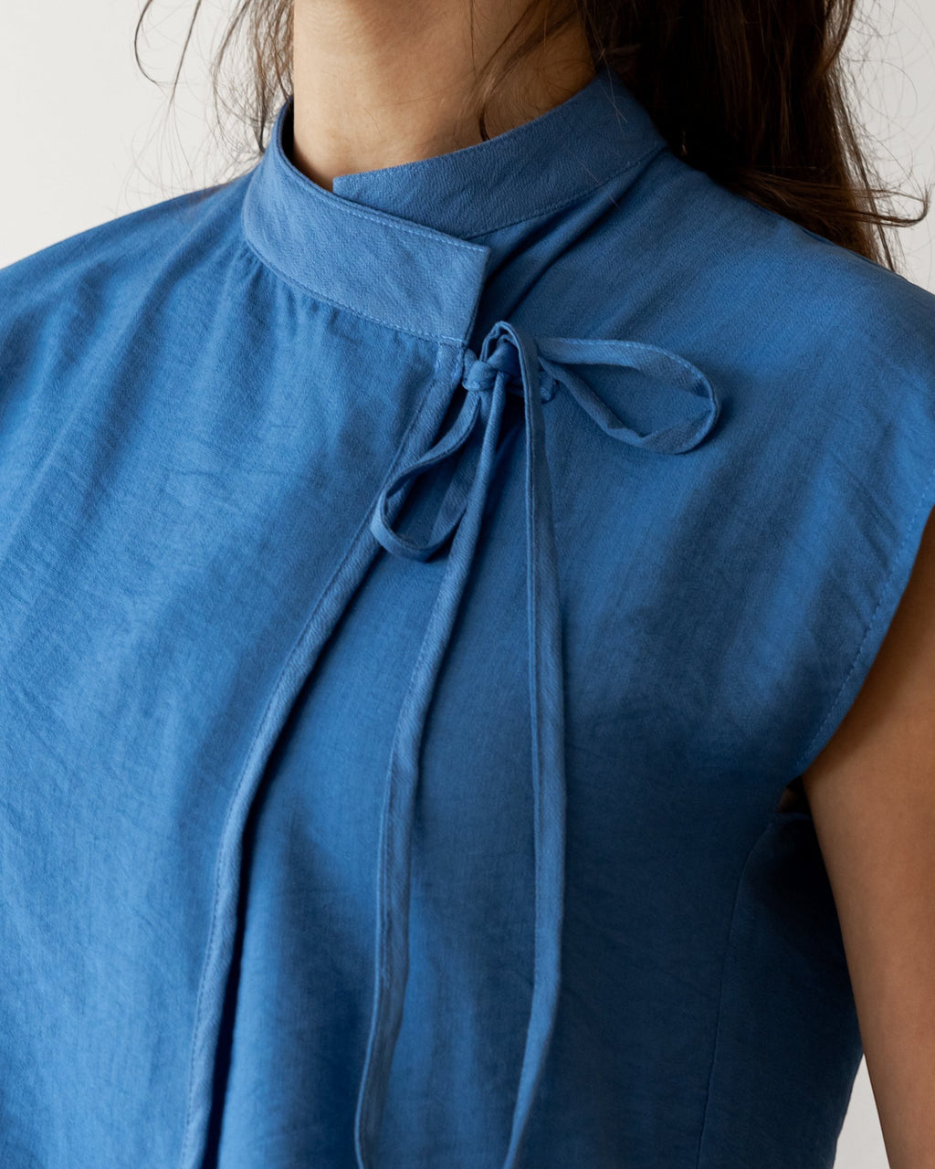 FSociety steel blue lightweight fabric knot top with mock neck, cap sleeves, and tie closure.